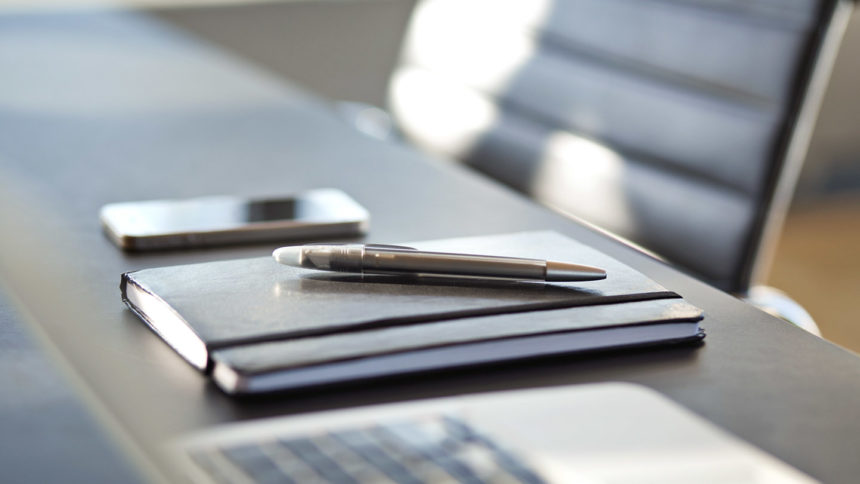 phone, notebook, pen on conference table