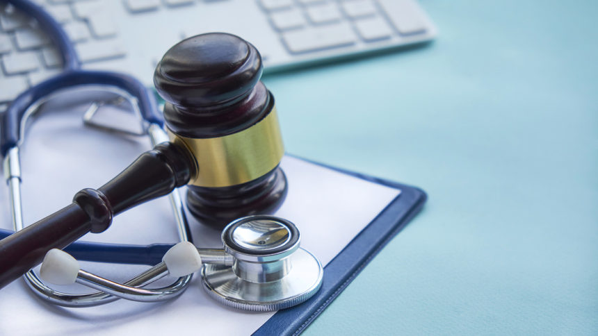 Gavel and stethoscope on computer keyboard