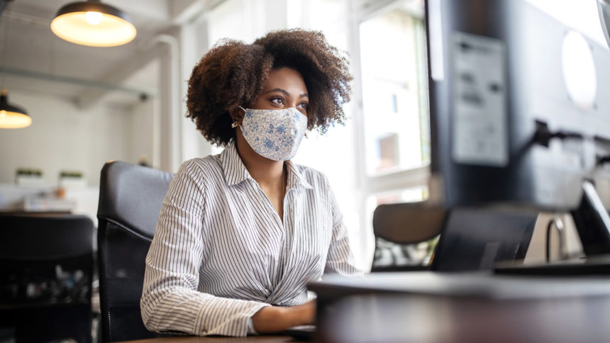 Businesswoman with face mask working at her desk