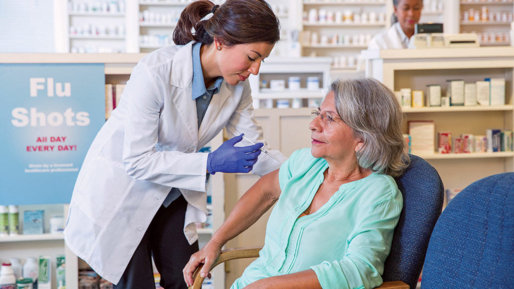woman gives older woman a flu shot
