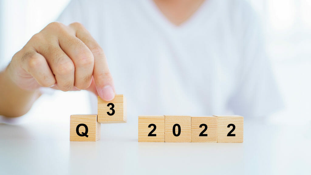 Unrecognizable Asian businessman turning a wooden blocks shown the word "Q2 2022 to Q3 2022" close up with copyspace. Quarterly business report concept.