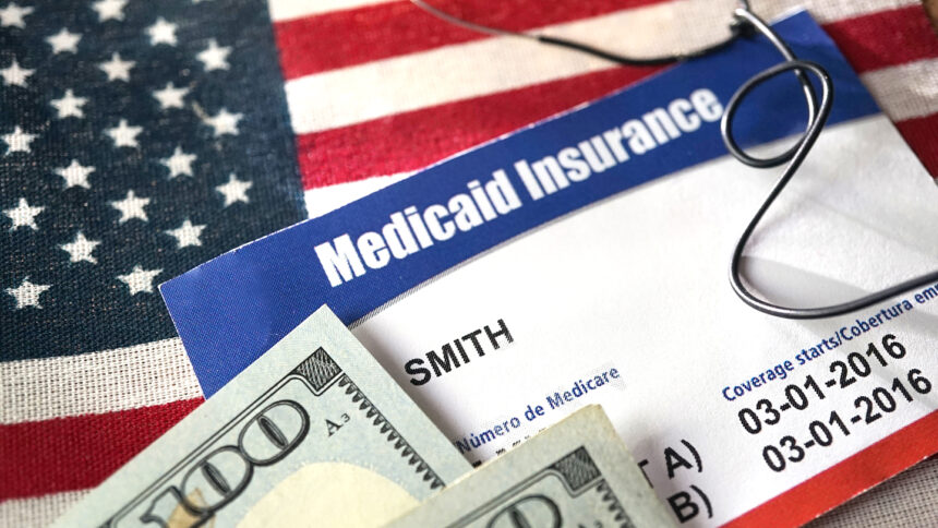 Medicaid card and cash atop American flag
