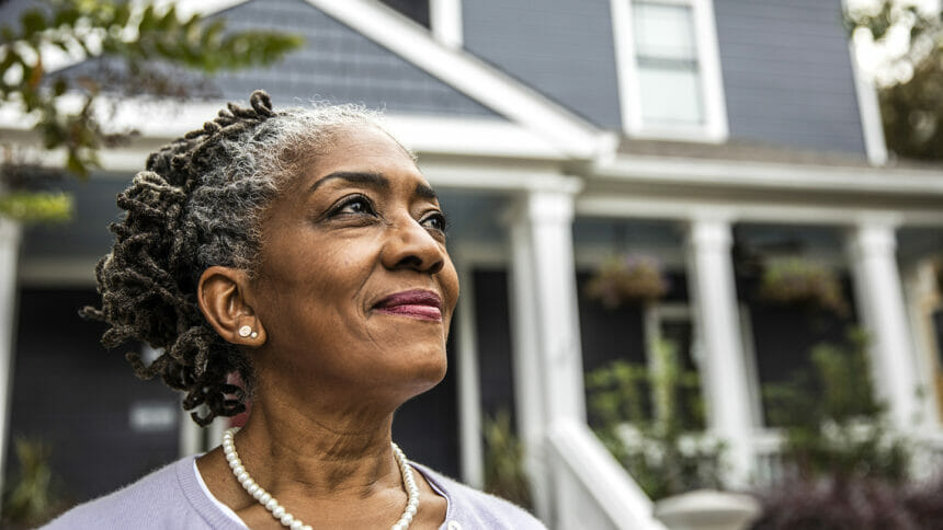 Portrait of senior woman in front of suburban home