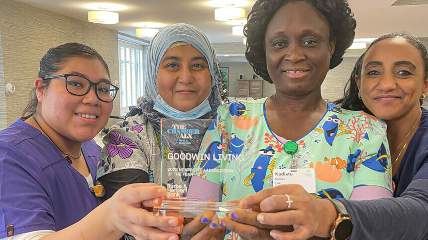 Group of 4 caregivers holding a glass trophy.