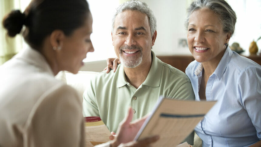 Hispanic saleswoman talking to clients in living room