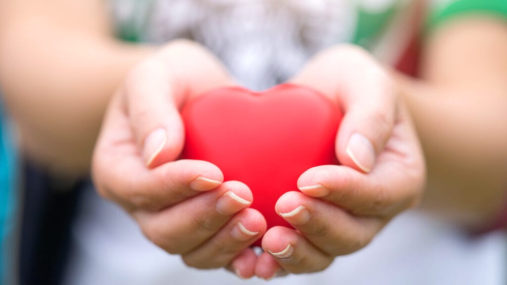 Women hand holding heart, heart disease concept