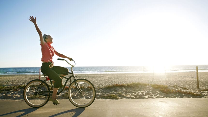 Caucasian woman riding bicycle near beach