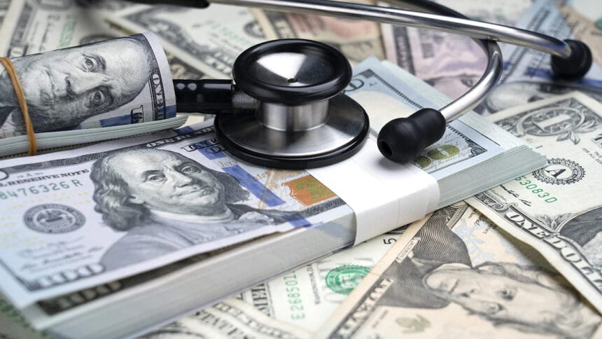 stethoscope and US dollars on color background
