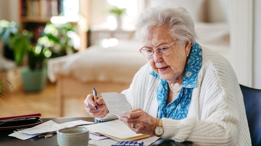 Senior woman has financial problems. Counting money, monthly pension, don’t have enough money for paying bills.