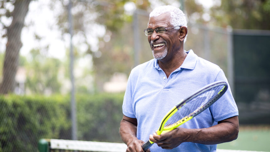 Portrait of a senior black man with a tennis racket
