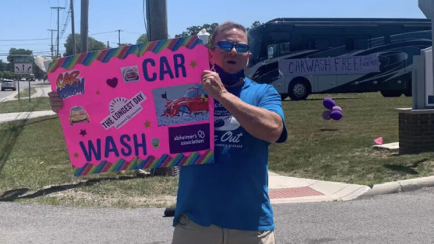 man holding car wash sign