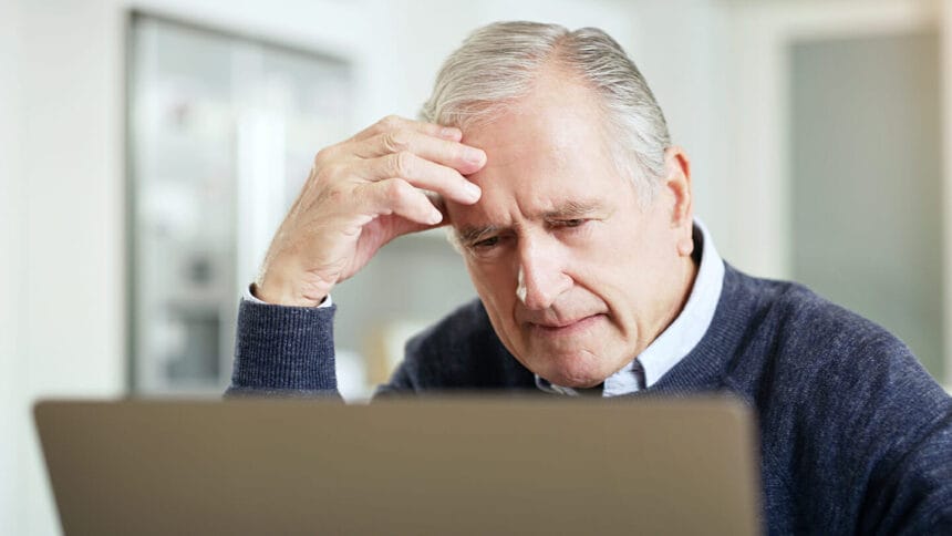 older man looking at laptop computer screen