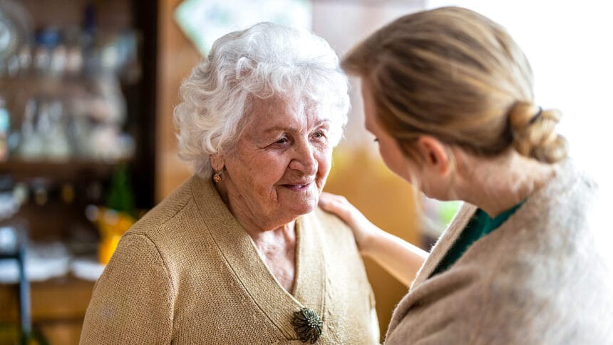 Health visitor talking to a senior woman during home visit