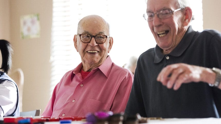 Senior men laughing playing bingo together