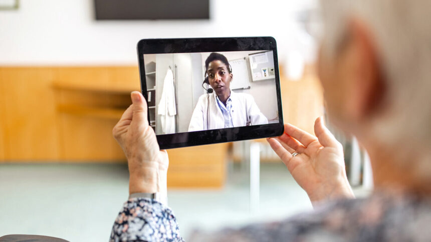 older adult holding iPad and communicating with someone