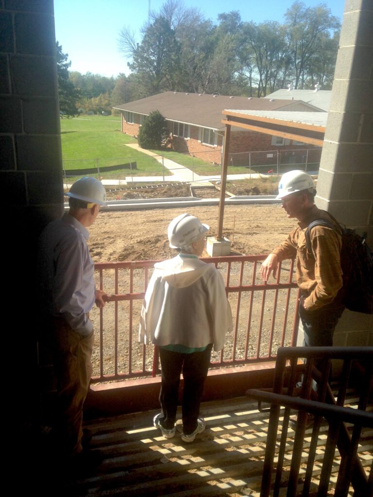 older woman looking at a senior living community construction site.