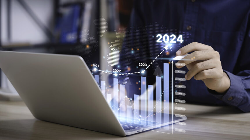 Businessman analyzes the graph of trend market growth in 2024 and plans business growth and profit increase in the year 2024. plan finances of the business