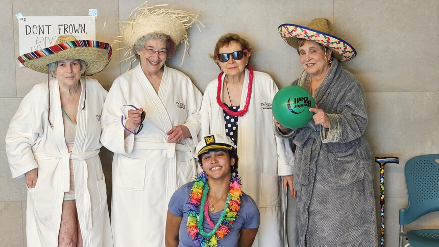 student huddled with older adults in robes