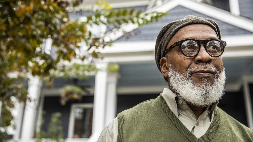 Portrait of senior man in front of suburban home