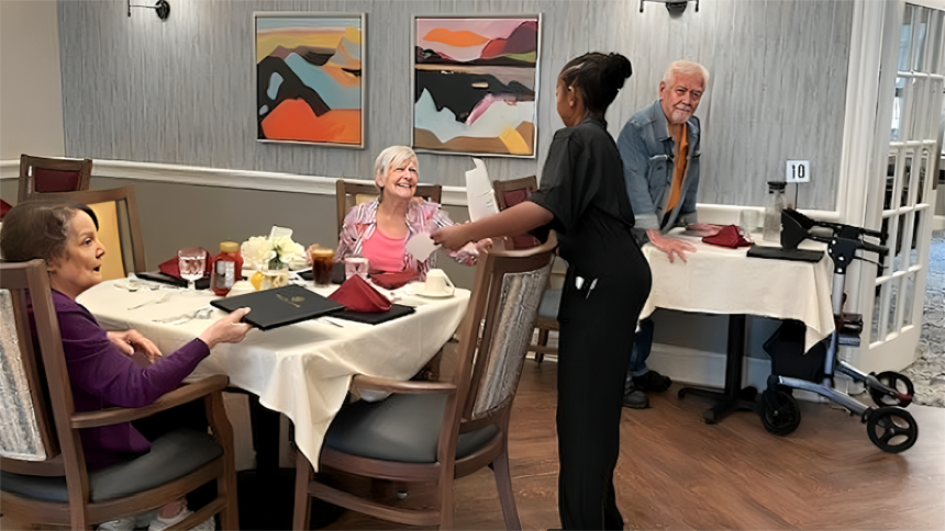 student serving reisdents in dining room