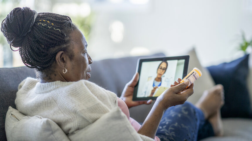 Senior African American woman speaking with her general practitioner via video call during the COVID-19 pandemic to avoid an in person appointment.