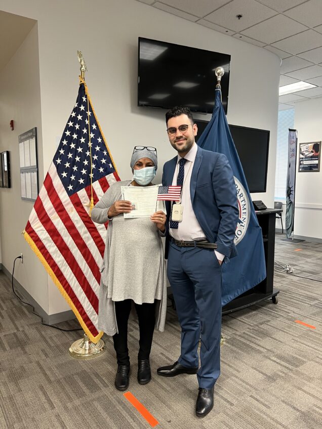 woman in mask holds citizenship certificate with son