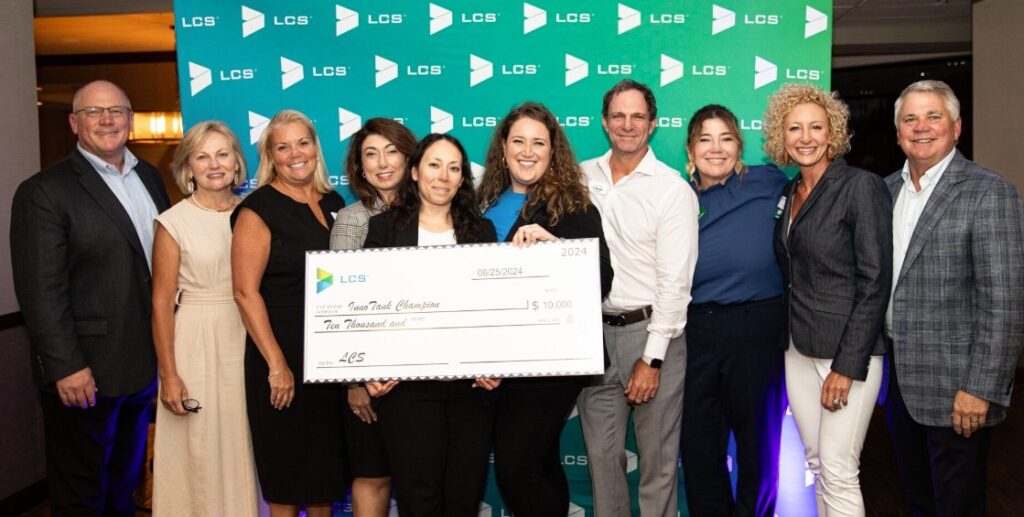 people posing with large check