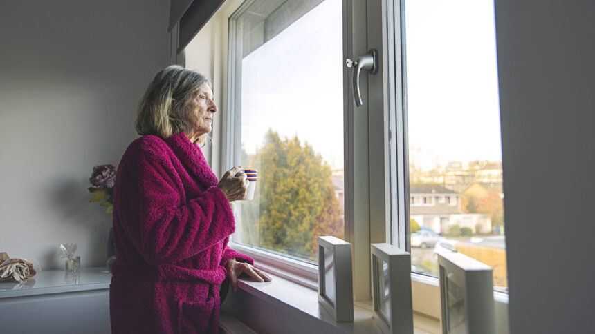 Sad senior woman looking out of the window