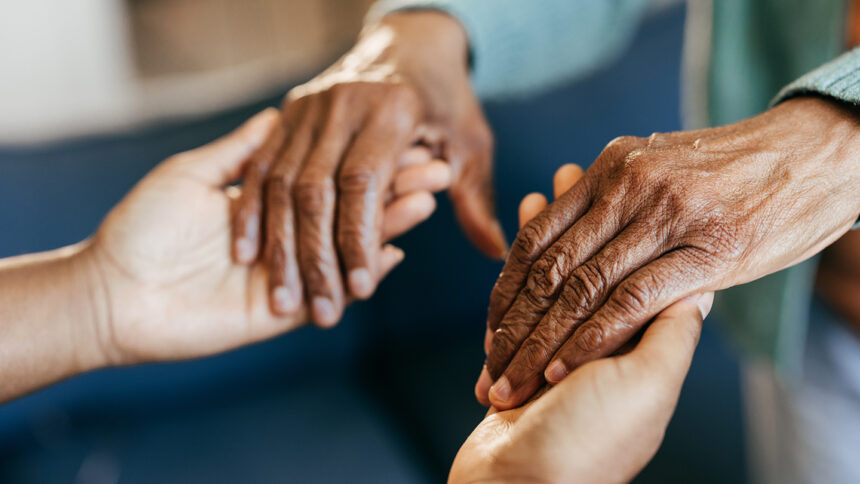 Young woman holding elderly hands